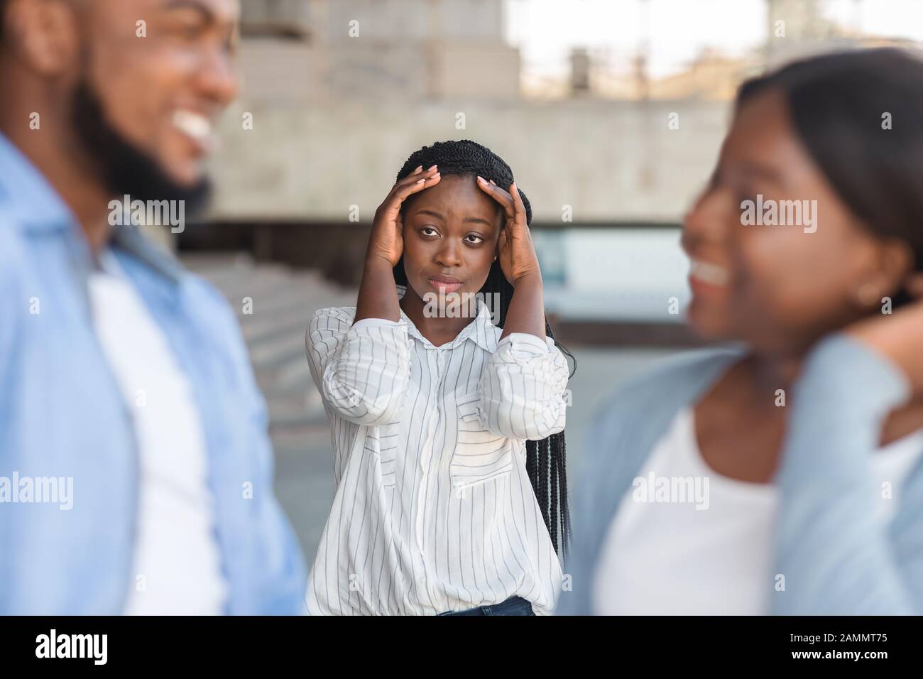 Verärgerte schwarze Frau, die beobachtet, wie ihr Freund draußen mit anderen Mädchen flirtet Stockfoto