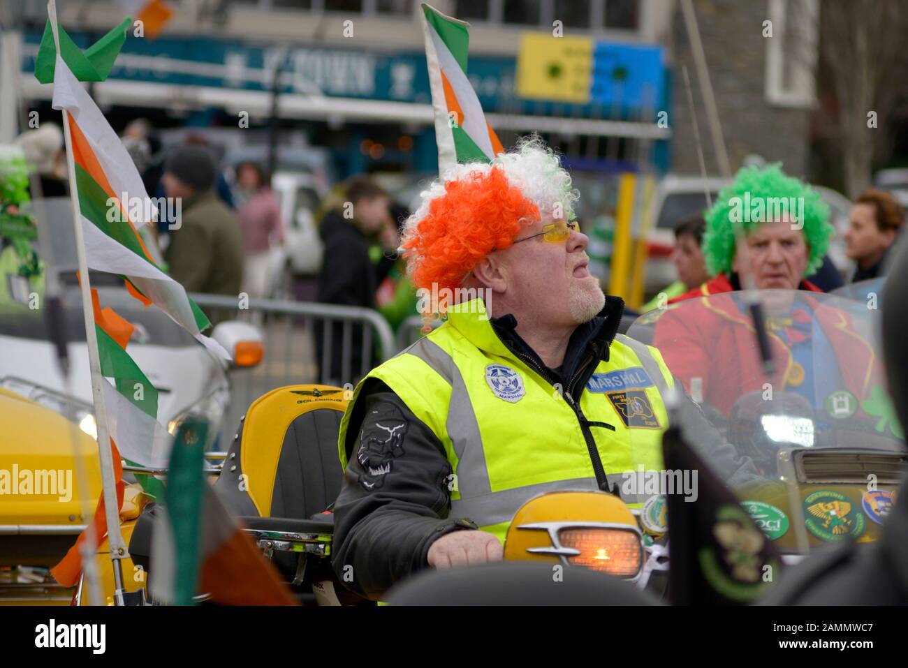 Erwachsener Rocker mit irischer Tricolour-Perücke auf einem Motorrad, der an der jährlichen St. Patrick's Day Parade Festival und Feierlichkeiten in Killarney, County Kerry, Irland, ab 17. März 2019. Stockfoto