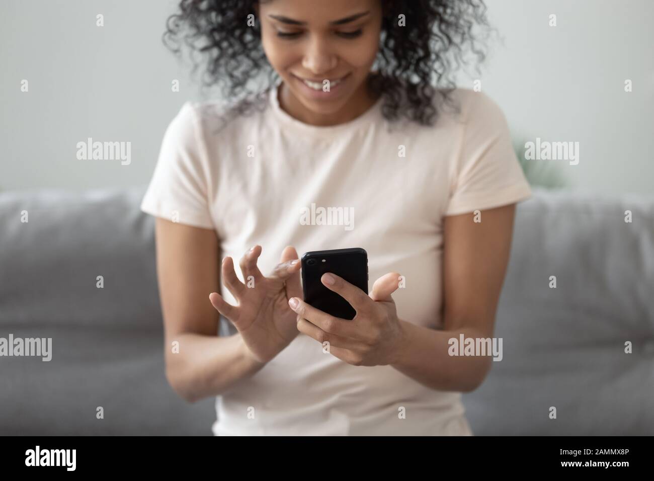 Afrikanerin hält Smartphone-Nahaufnahme im Fokus auf Hände und Gadget Stockfoto