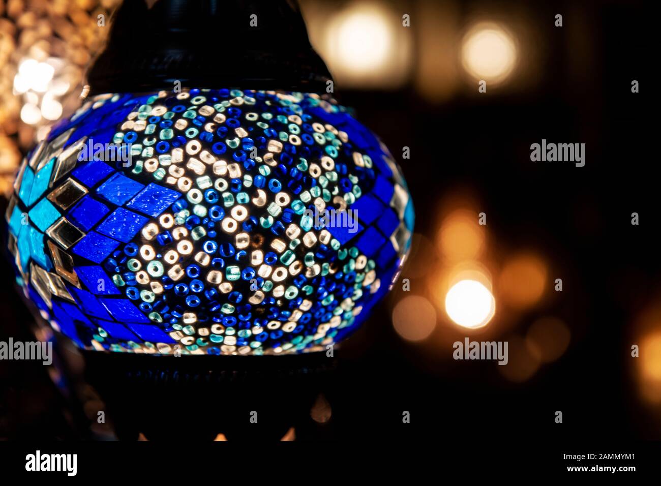 Bunte blaue marokkanische Lampe mit blauem Mosaikdesign aus Glas. Orientalischer Stil. Vor Bokeh-Hintergrund. Stockfoto