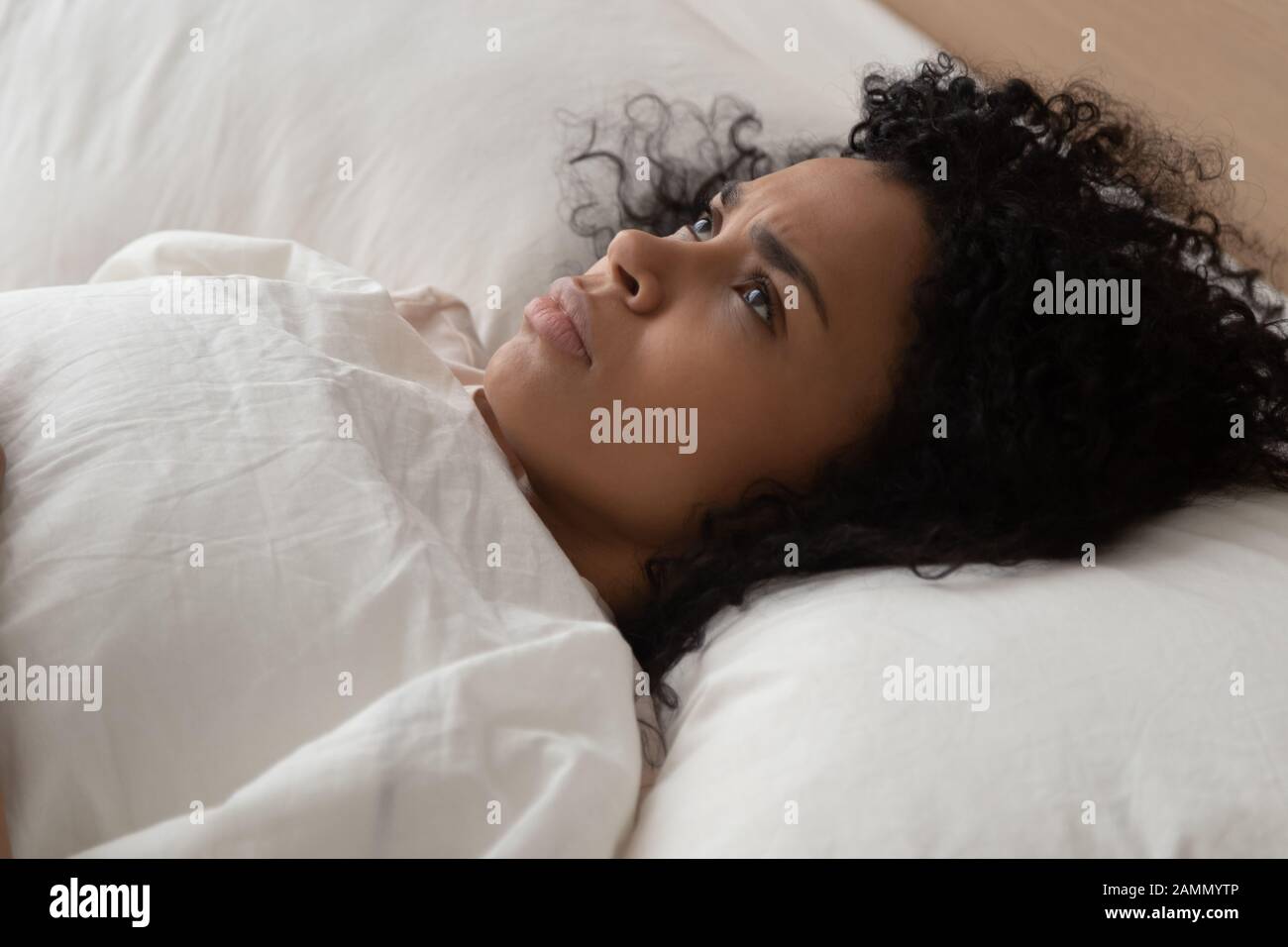 Frau, die im Bett liegt, kann nicht einschlafen, leidet unter Schlaflosigkeit Stockfoto