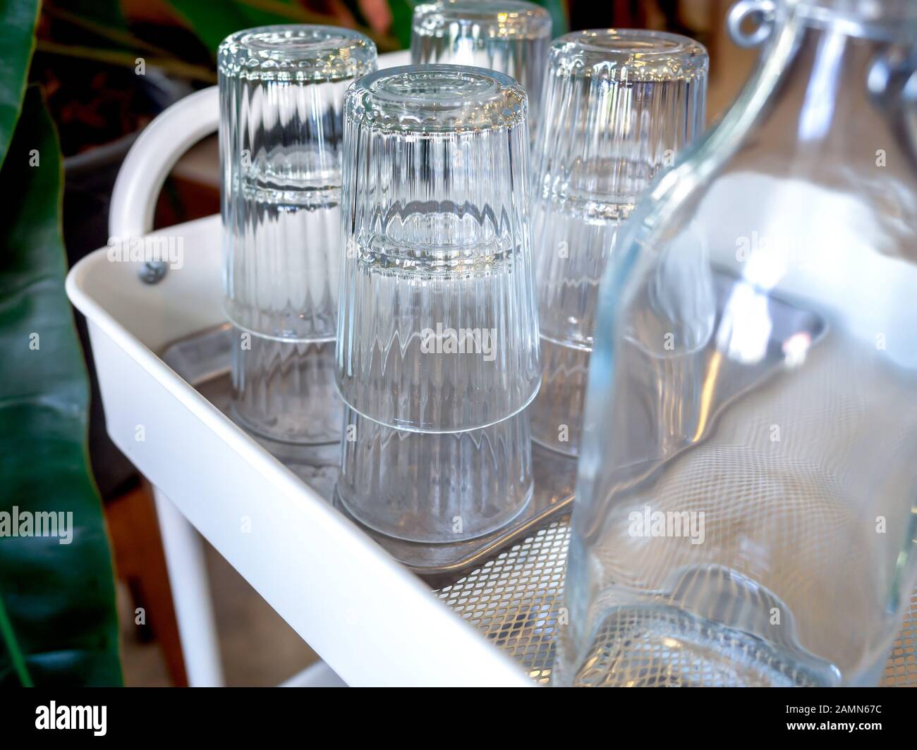 Kostenloser Trinkwasser-Selbstbedienung im Café. Glashaufen in Tablett und Trinkwasser-Flaschen auf Trolley. Stockfoto Kostenloser Trinkwasser-Selbstbedienung im Café. Glashaufen in Tablett und Trinkwasser-Flaschen auf Trolley. Stockfoto