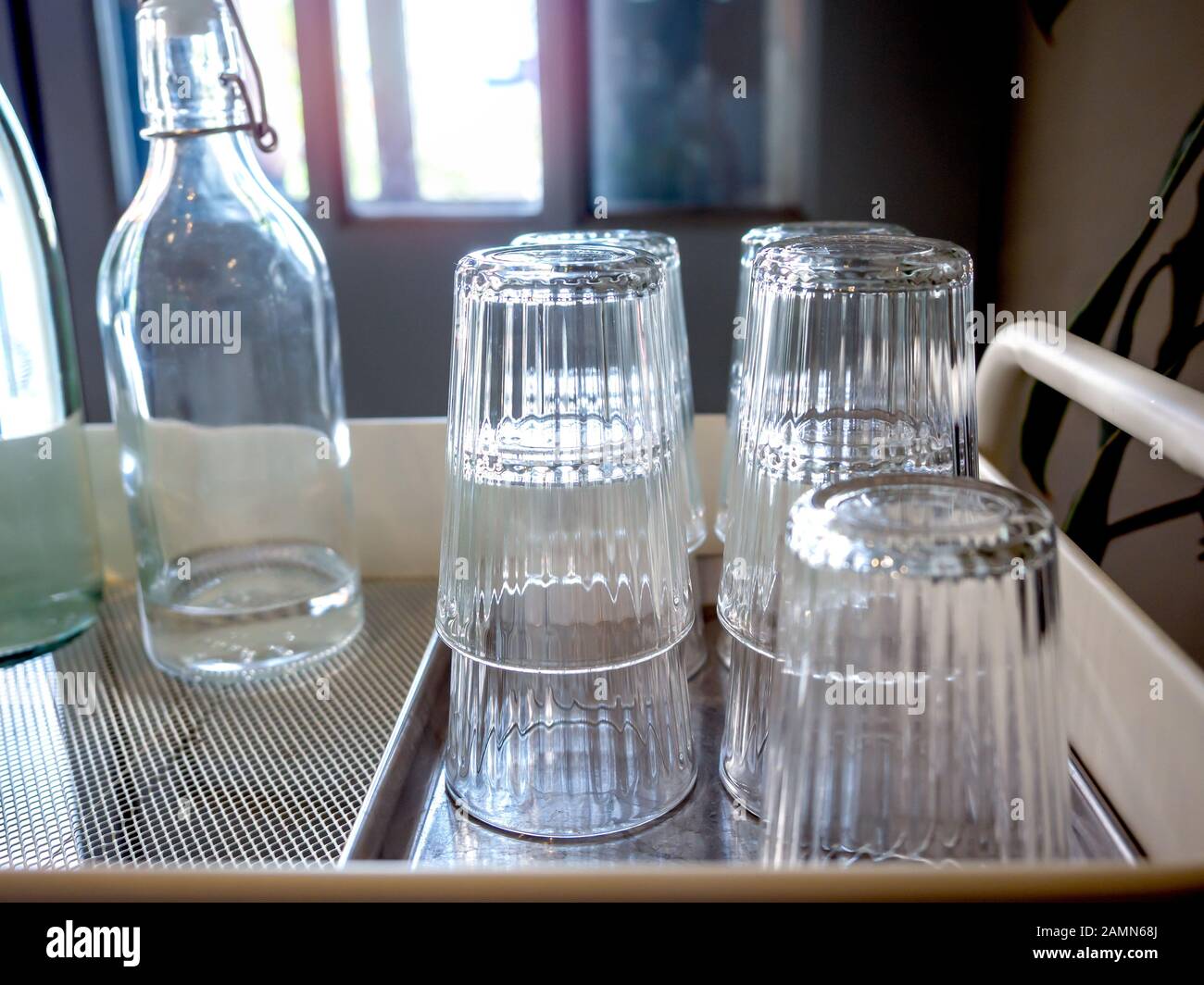 Kostenloser Trinkwasser-Selbstbedienung im Café. Glashaufen in Tablett und Trinkwasser-Flaschen auf Trolley. Stockfoto Kostenloser Trinkwasser-Selbstbedienung im Café. Glashaufen in Tablett und Trinkwasser-Flaschen auf Trolley. Stockfoto