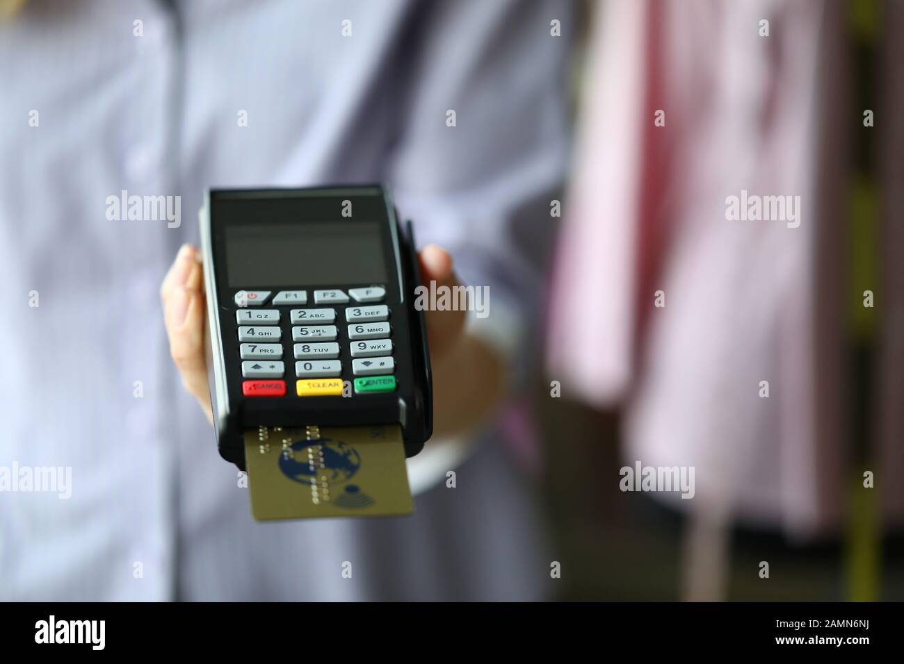 Frau hält POS-Termial mit Goldplastik-Debitkarte in der Hand Stockfoto