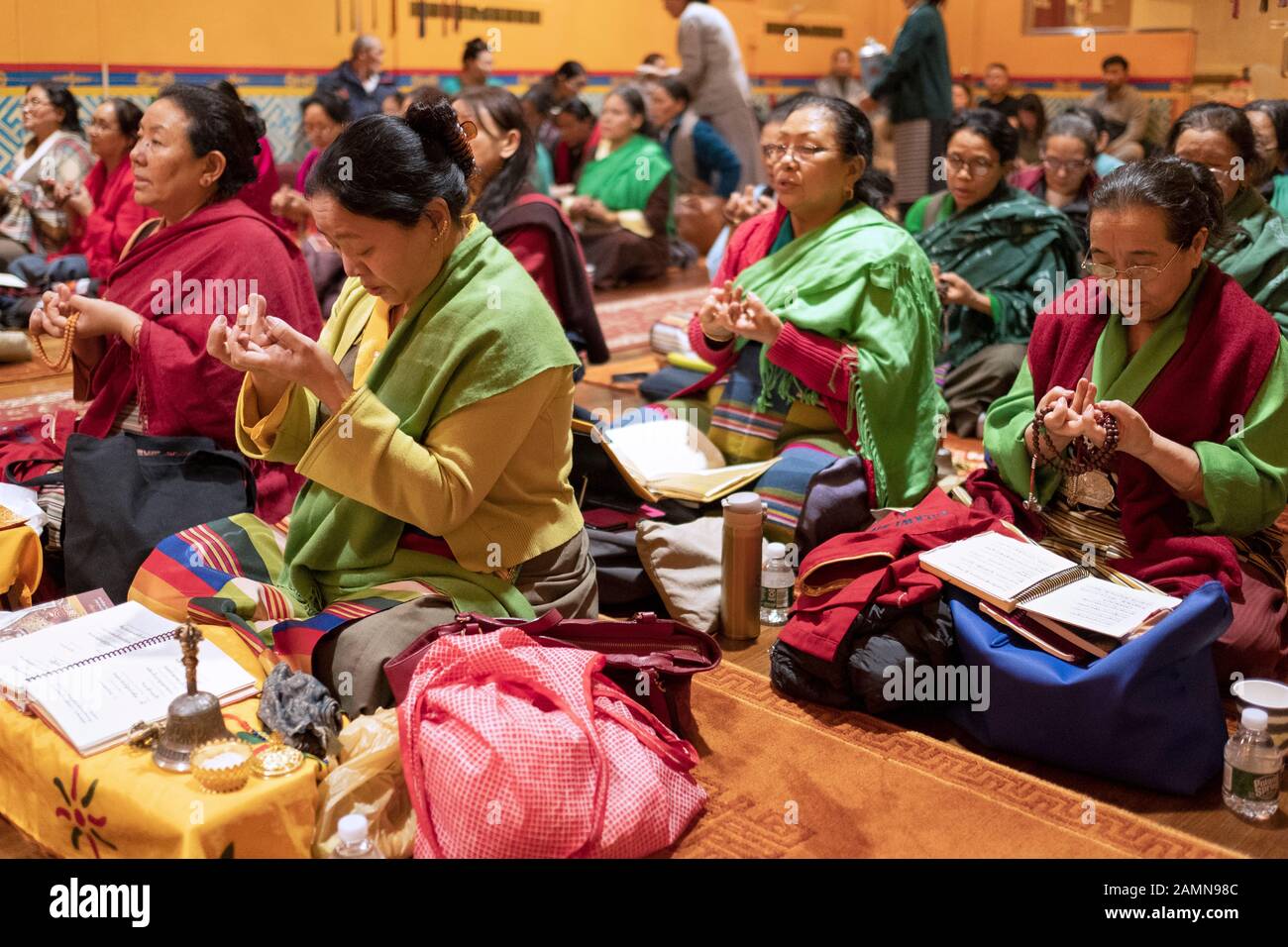 Verschlingen Sie buddhistische Frauen, die im Sitzen beten und meditieren und die entsprechenden Handgesten machen. In einem Tempel in Queens, New York City. Stockfoto