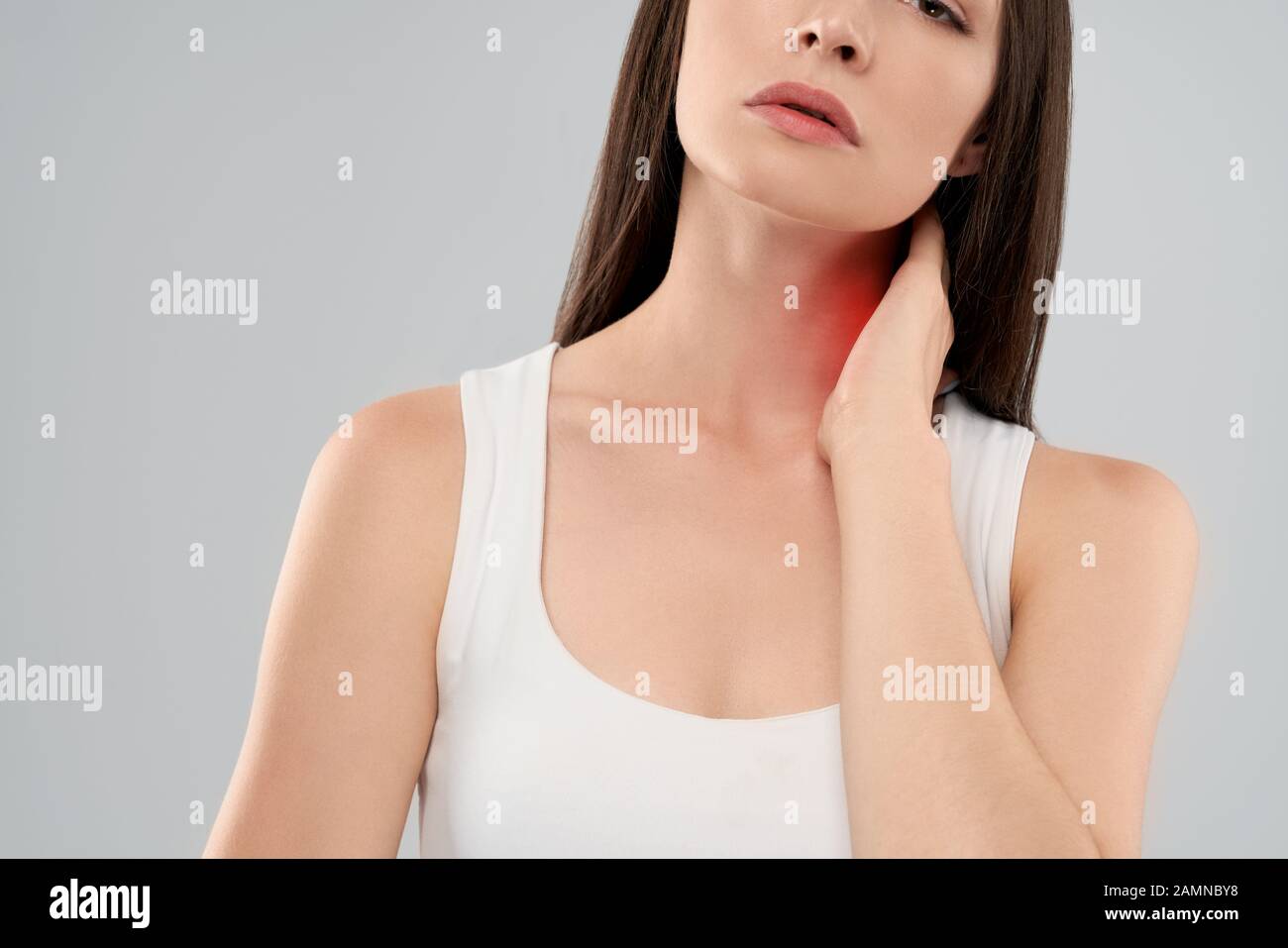 Clolse von Incognito kaukasische Frau in weißem Hemd Posing über Grau isoliert Hintergrund und Hals berühren mit der Hand wegen der Schmerzen. Crop von brunette Atmen mit den Mund. Stockfoto