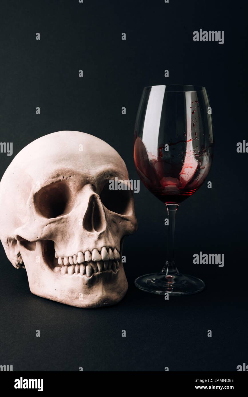 Schädel und Weinglas mit Blut isoliert auf Schwarz Stockfoto