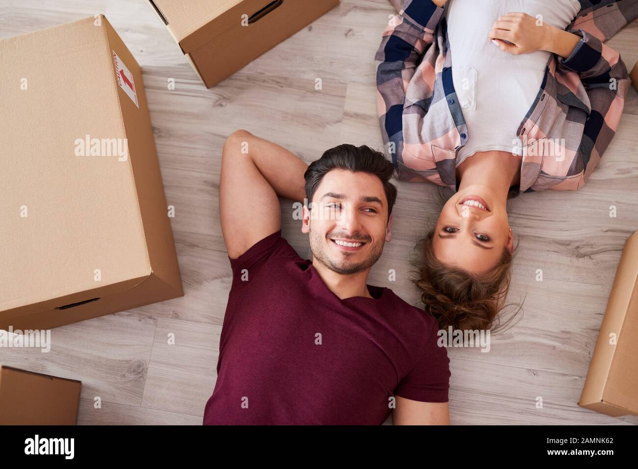 Porträt eines lächelnden Ehepaares, das Pause vom Umzug nach Hause nimmt Stockfoto