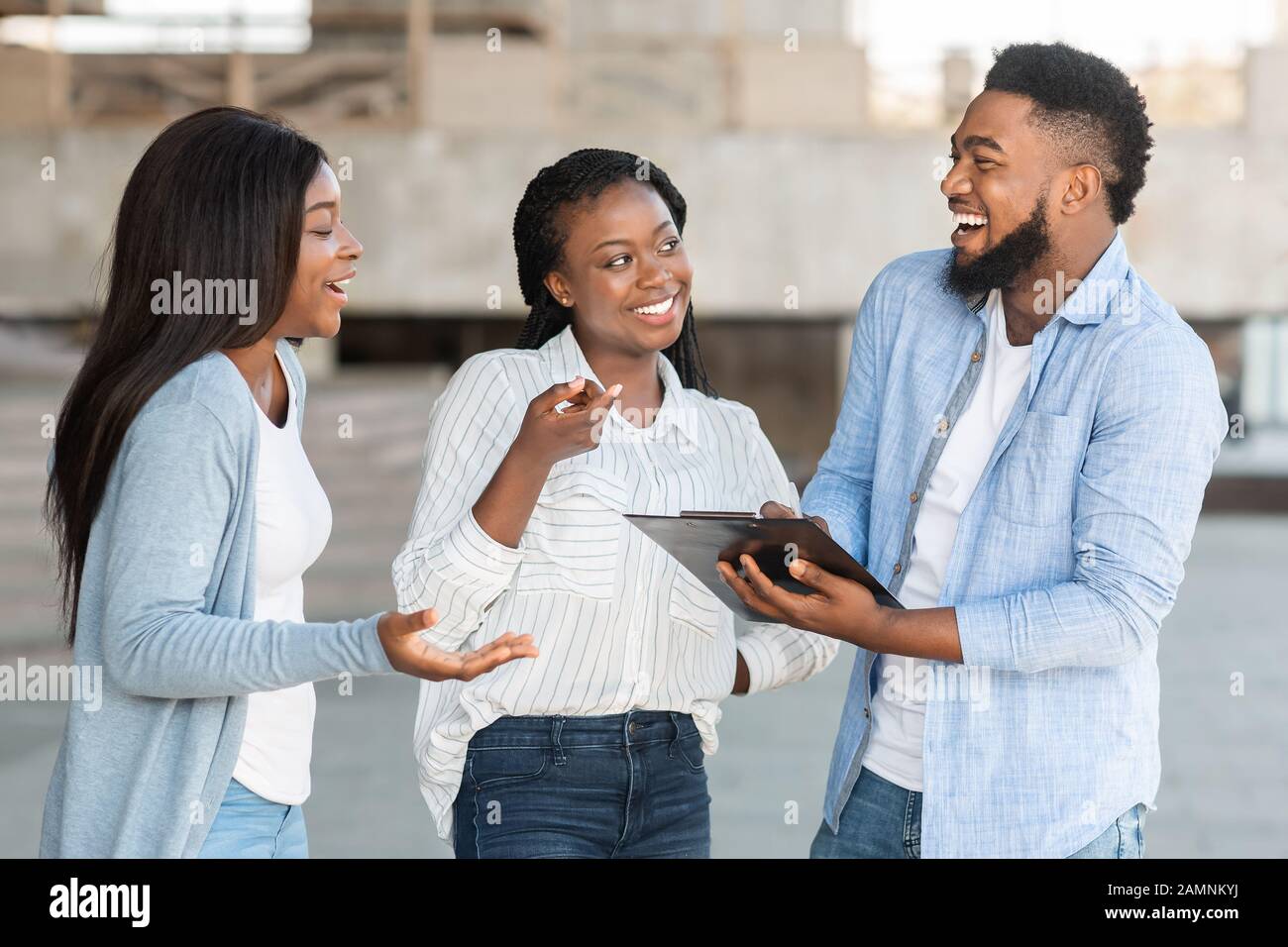 Fröhliches Afro-Paar, das den Fragebogen für soziale Forschung im Freien beantwortet Stockfoto