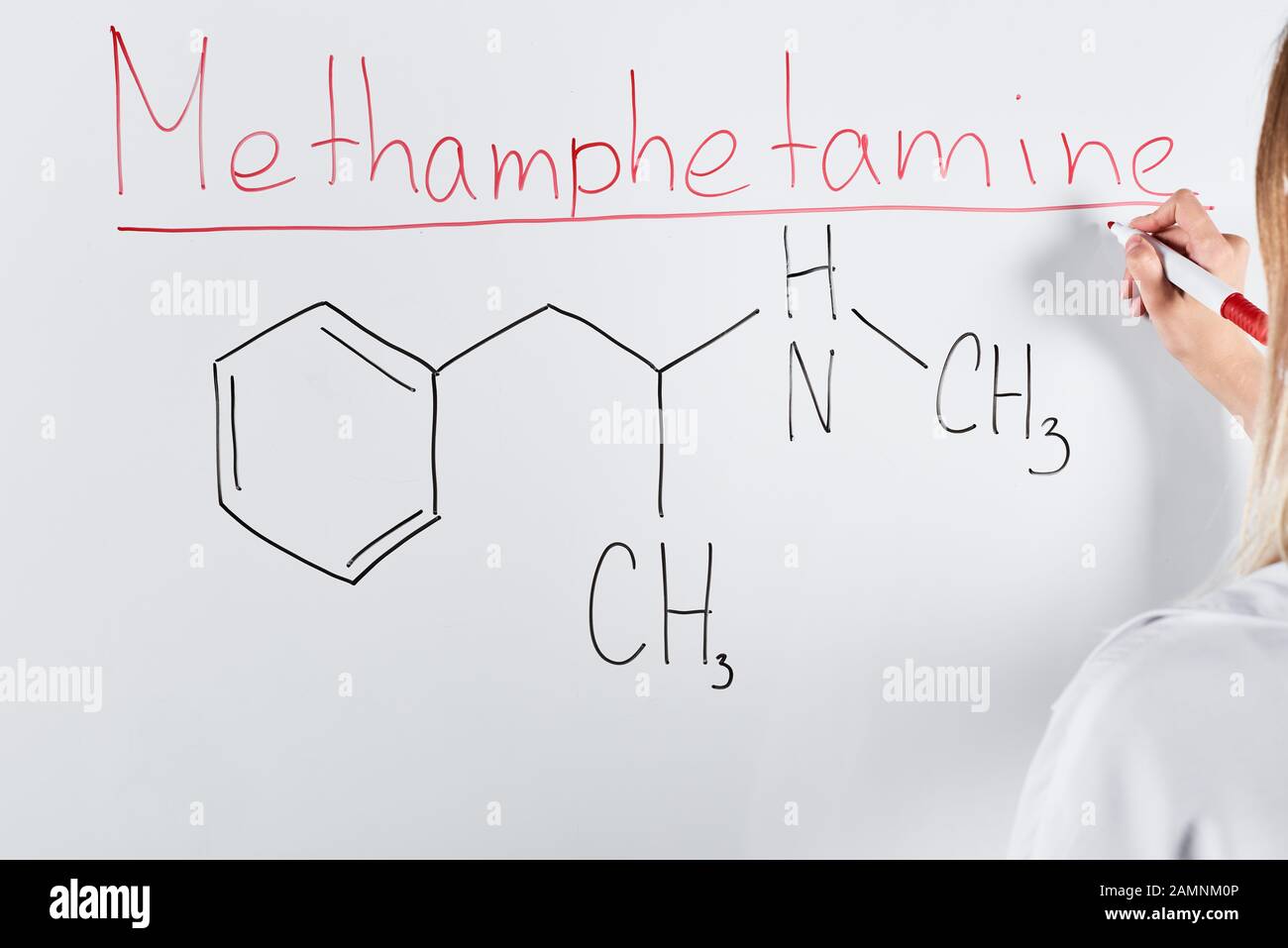 3/4-Ansicht der Frau, die Methamphetamin auf weißem Brett schreibt Stockfoto