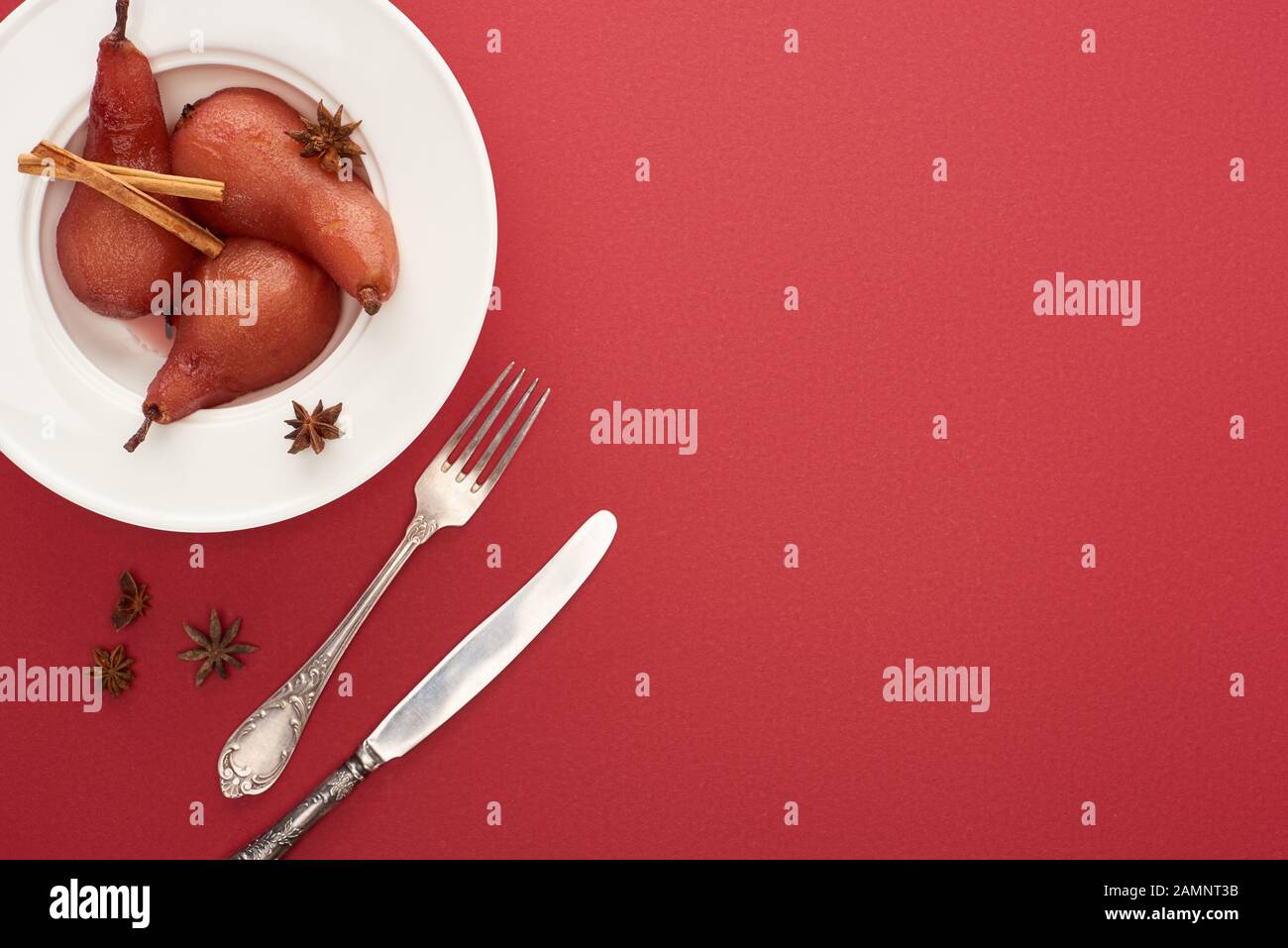 Draufsicht auf köstliche Birne in Wein mit Zimt und Anis auf Platte auf ...