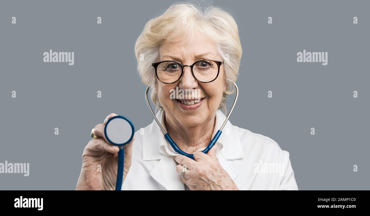 Lächelnde Oberärztin mit Stethoskop und Blick auf Kamera, Gesundheitswesen und Prävention Stockfoto