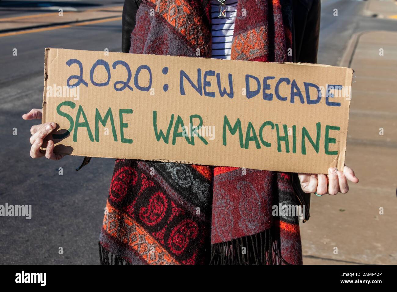 Protest gegen Krieg 2020 - Neue Decade-Same War Machine - Frau in Schal hält hausgemachte Zeichen Stockfoto