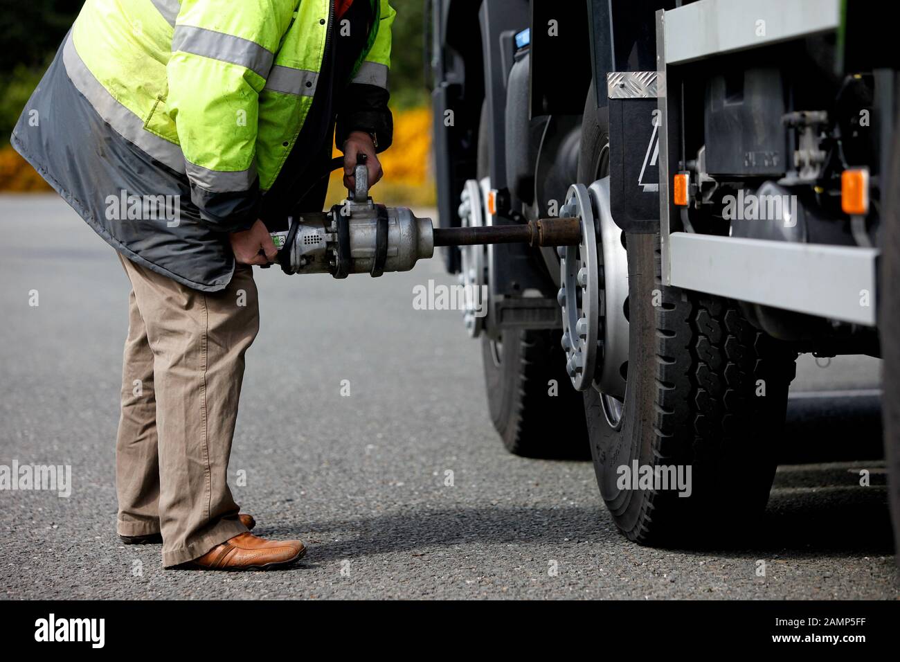 Ein Mechaniker ändern das Rad auf einem Lastwagen. Stockfoto