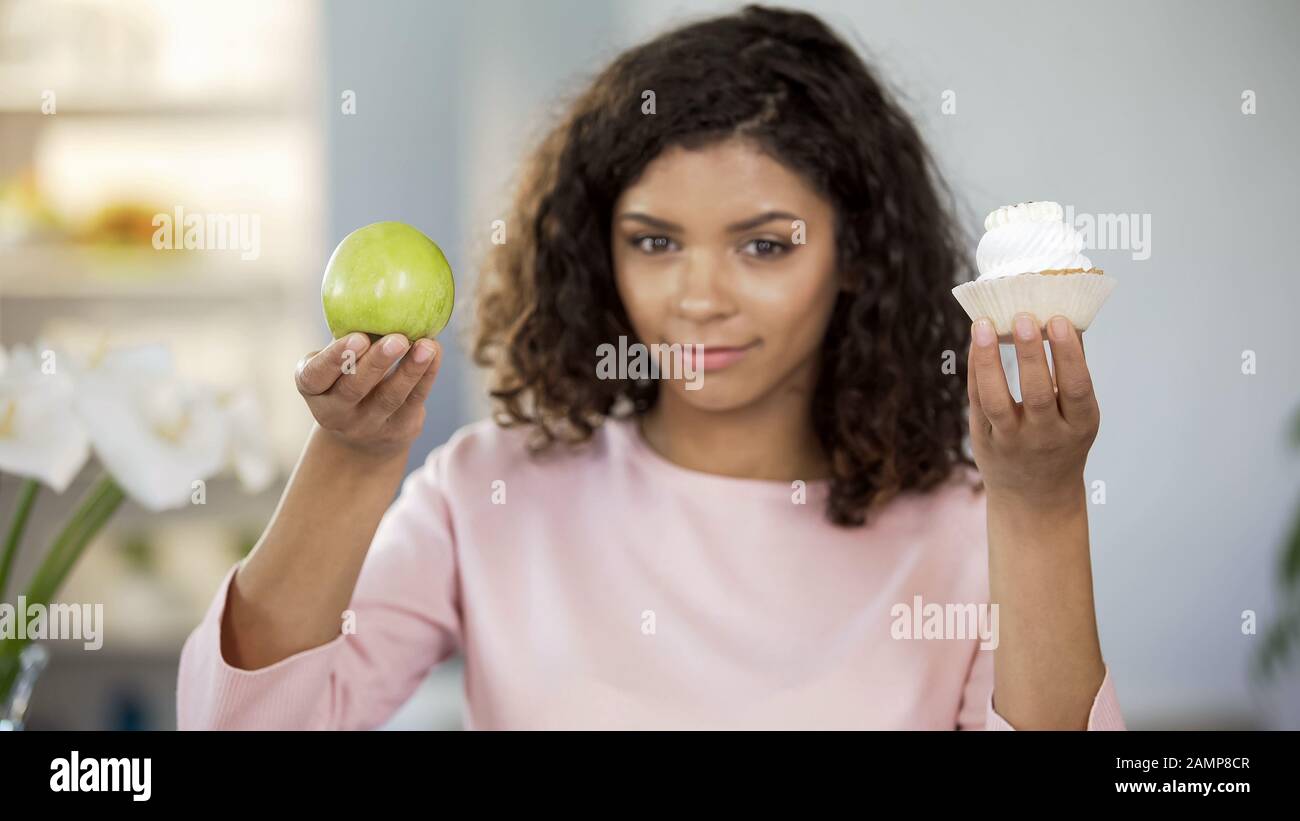Schöne Dame mit Kuchen und apfel, Essensauswahl, gesunder Ernährung Stockfoto