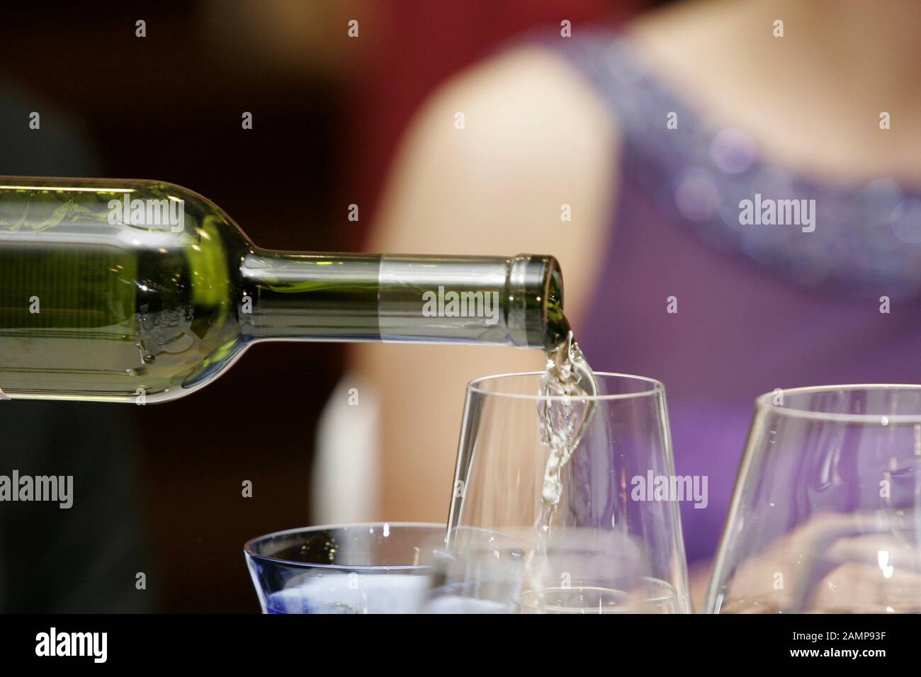 Nahaufnahme des Weißweins, der in einen Weinpass gegossen wird. Stockfoto