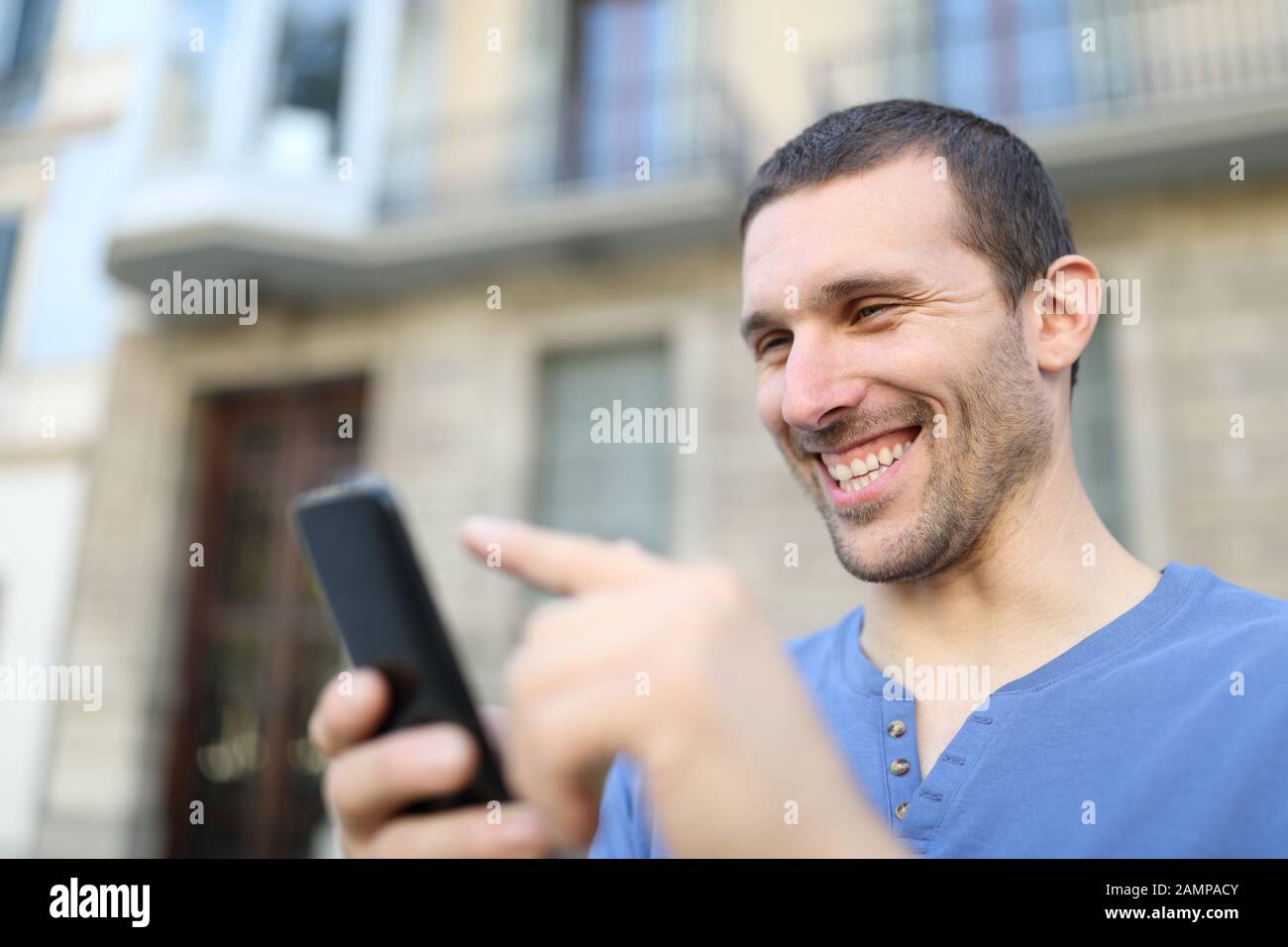 Glücklicher Erwachsener, der Handyinhalte auf der Straße durchstöberte Stockfoto