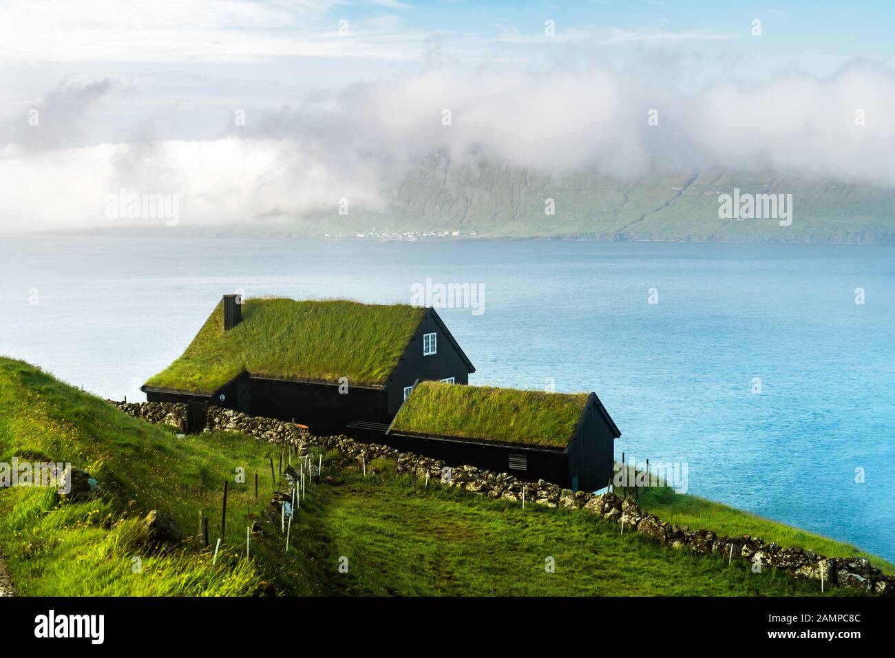 Nebeliger Blick auf ein Haus mit Grasdach im Dorf Velbastadur auf der Insel Streymoy, den Inseln der Färöer, Dänemark. Landschaftsfotografie Stockfoto