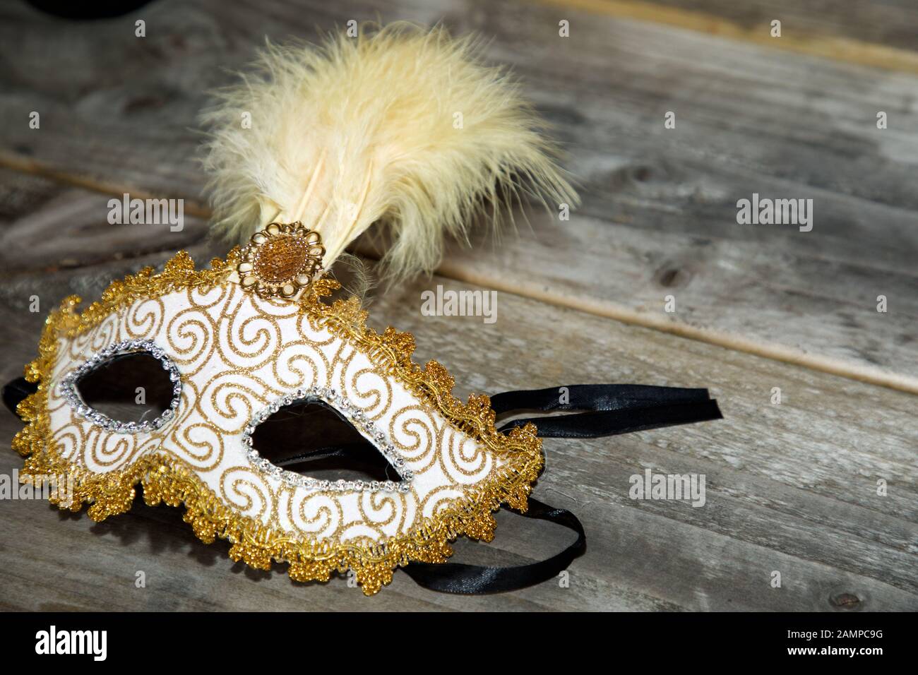 Nahaufnahme einer Maskenball-Maske auf einer Holzfläche. Stockfoto