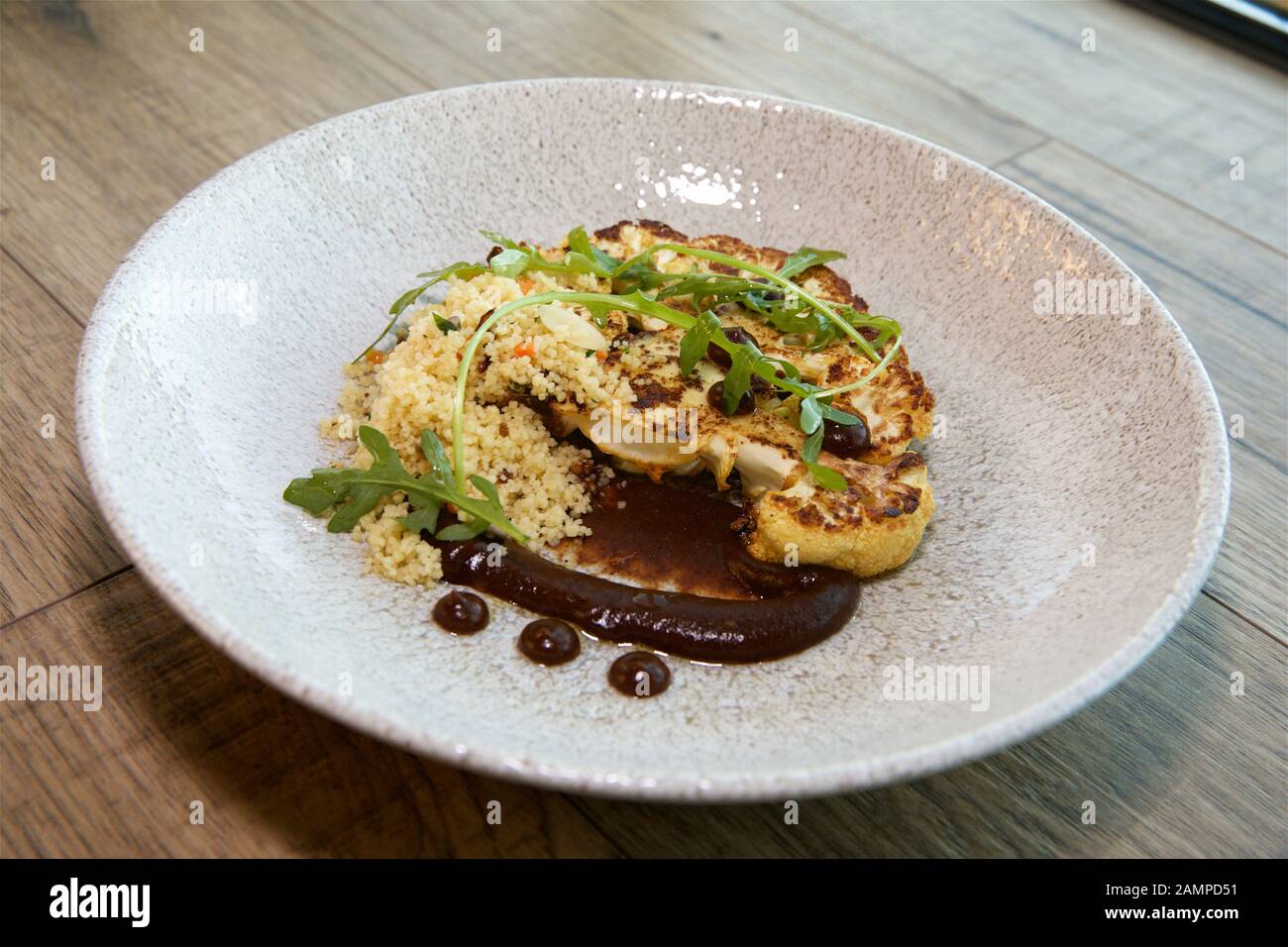 Vegetarisches Restaurant Gericht mit gegrilltem Blumenkohl und Couscous. Stockfoto