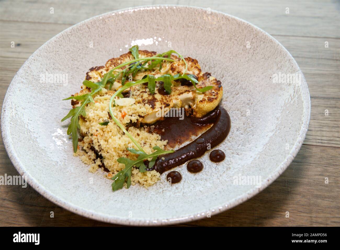 Vegetarisches Restaurant Gericht mit gegrilltem Blumenkohl und Couscous. Stockfoto