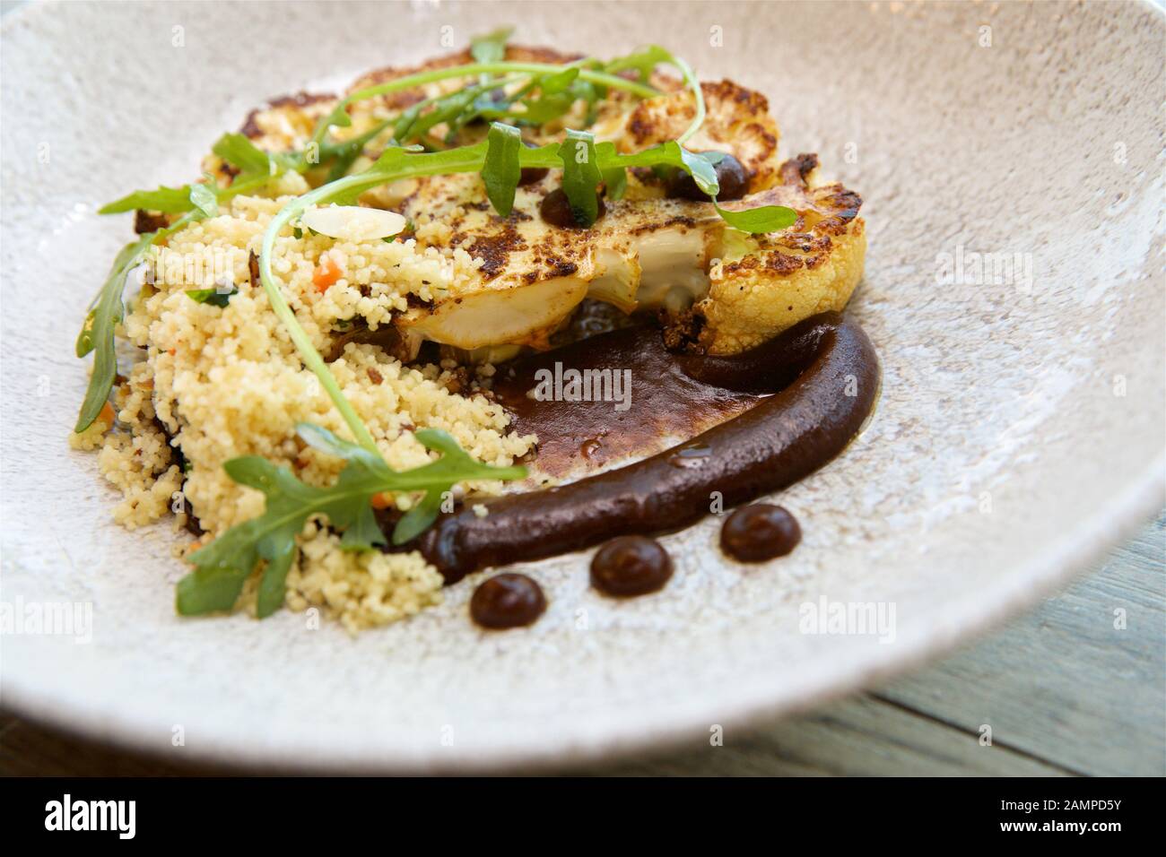 Vegetarisches Restaurant Gericht mit gegrilltem Blumenkohl und Couscous. Stockfoto