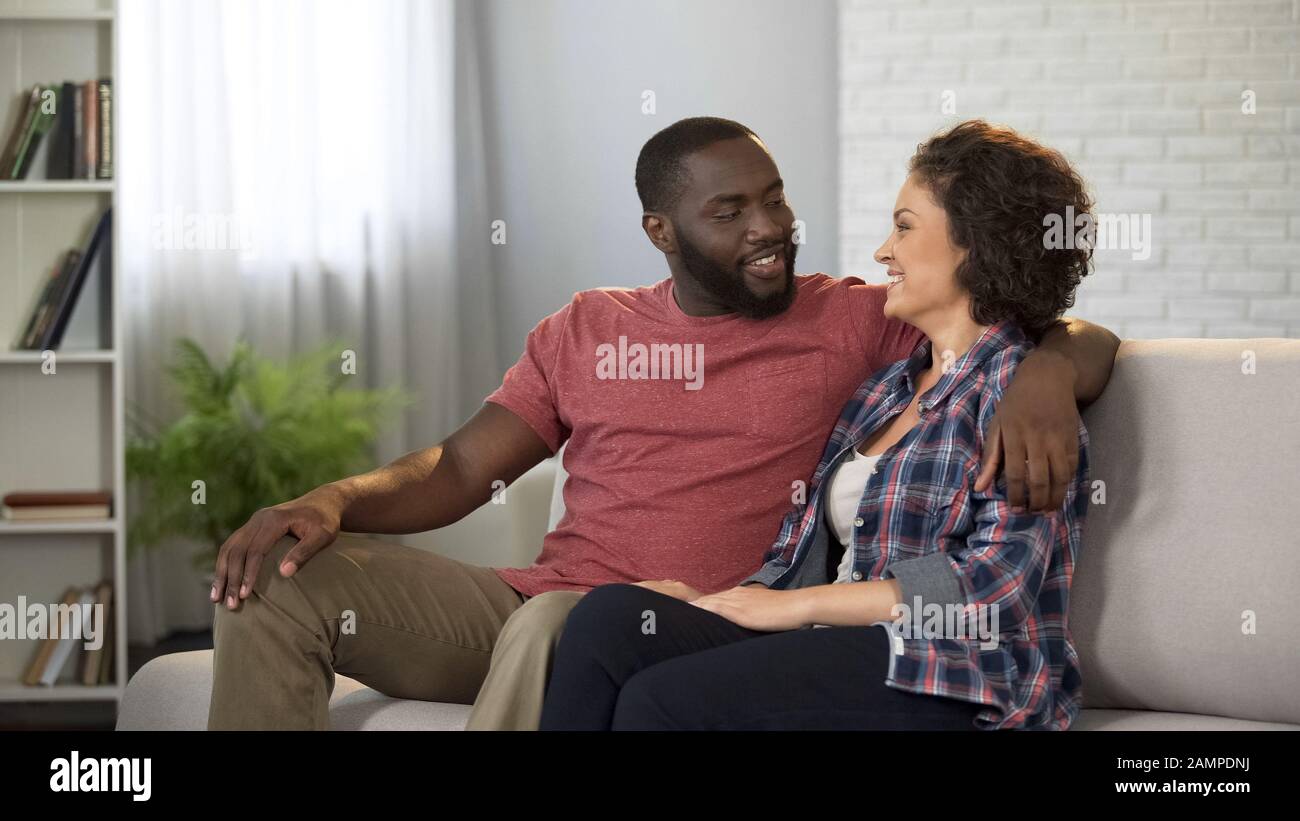 Glückliches Familienpaar sitzt auf dem Sofa und genießt Zeit zusammen, Beziehungsharmonie Stockfoto