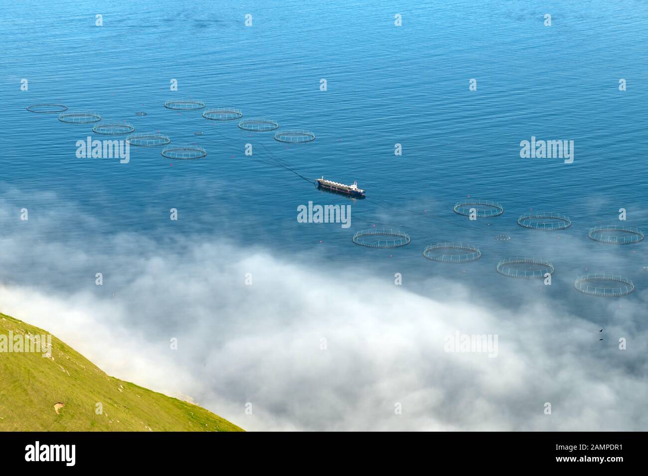 Fischfarm mit Schiff auf foggen Fjorden von Funningur, Insel Eysturoy, Färöer. Landschaftsfotografie Stockfoto