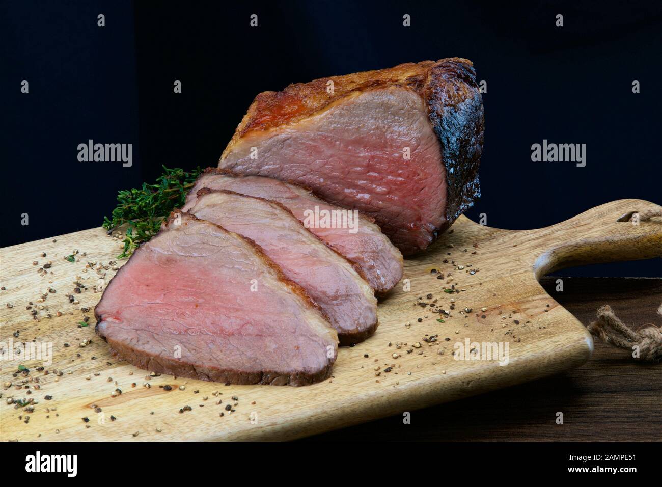 Nahaufnahme einer gemeinsamen von saftigen Roastbeef in Scheiben geschnitten auf einer hölzernen Platte. Stockfoto