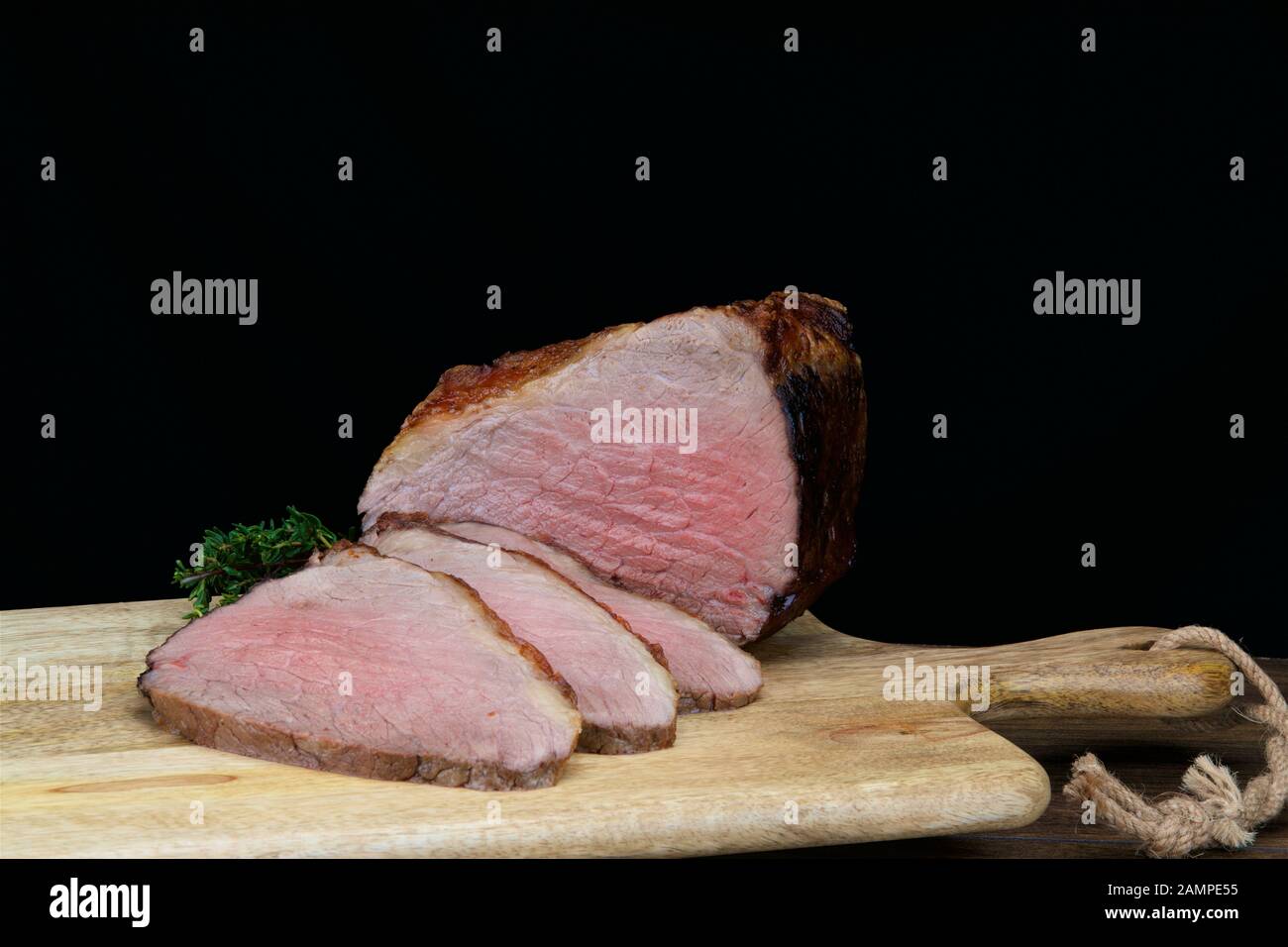 Nahaufnahme eines Gelenks saftigen irischen Roastbeef, das auf einer Holzplatte geschnitten wurde. Stockfoto