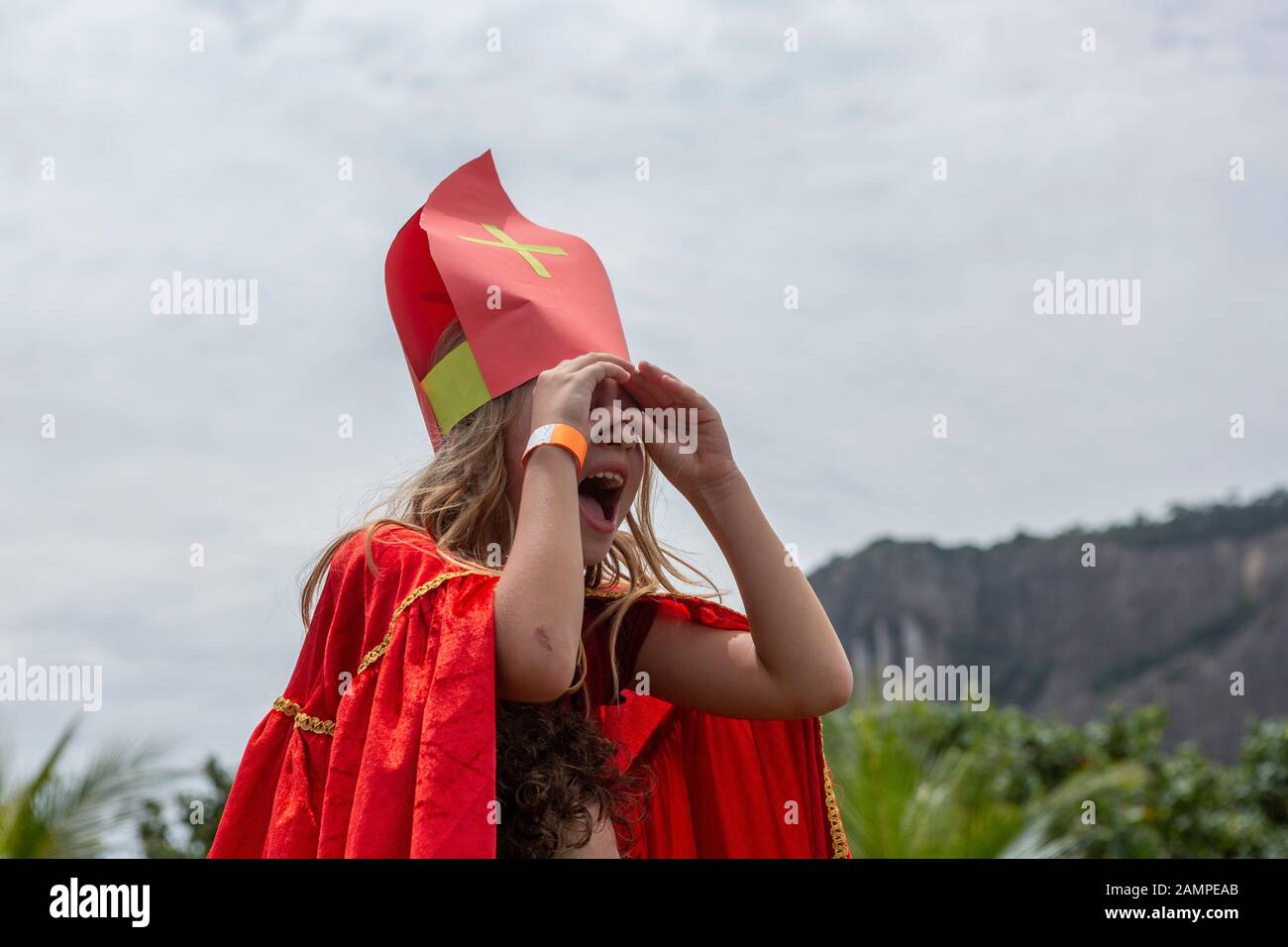 Junge Mädchen auf der Suche nach Sinterklaas Ankunft in Rio de Janeiro auf der Stadt see ufer mit ihren Händen wie Fernglas Stockfoto