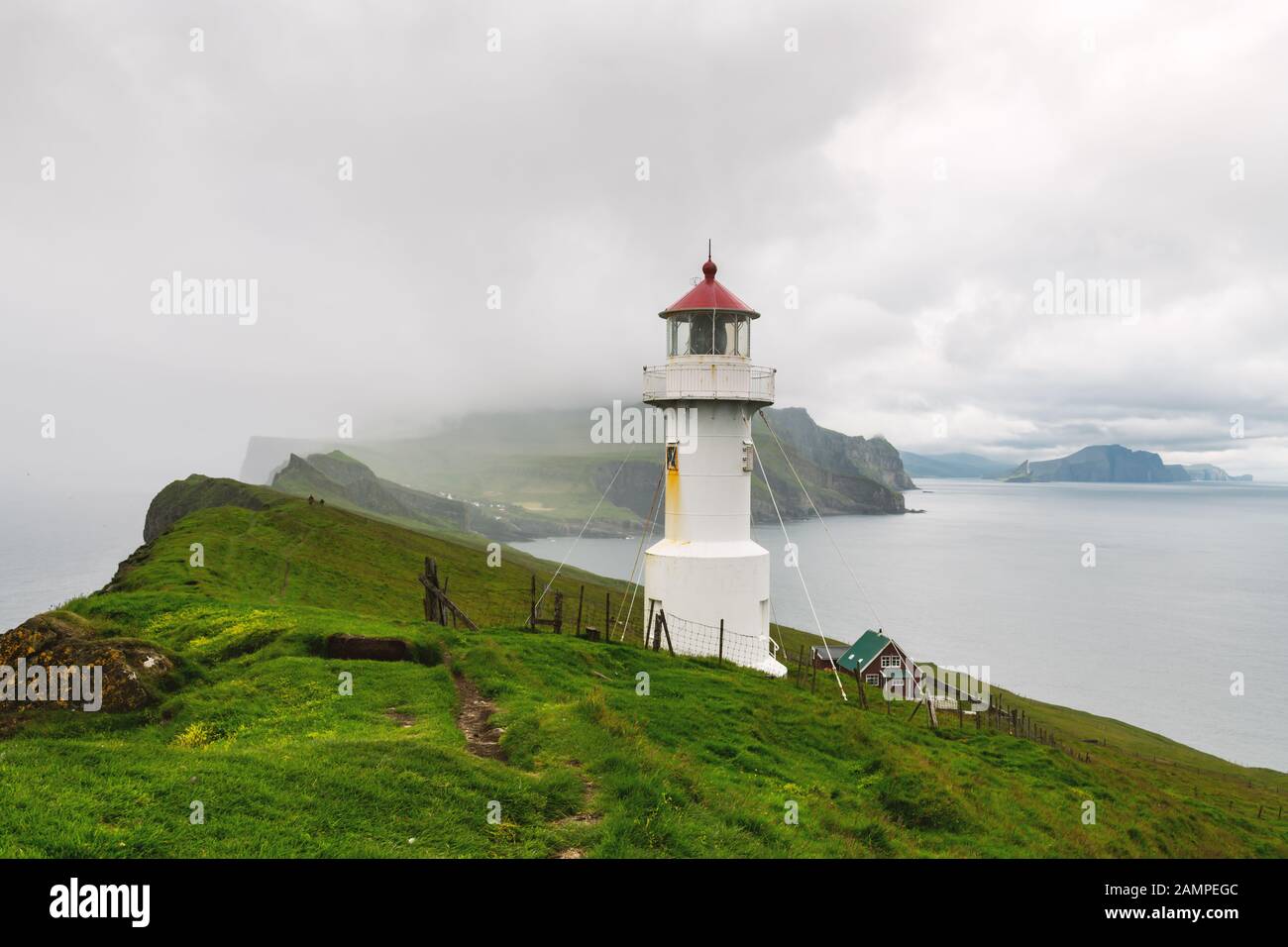 Nebel Blick auf alte Leuchtturm auf der Insel Mykines, Färöer, Dänemark. Landschaftsfotografie Stockfoto