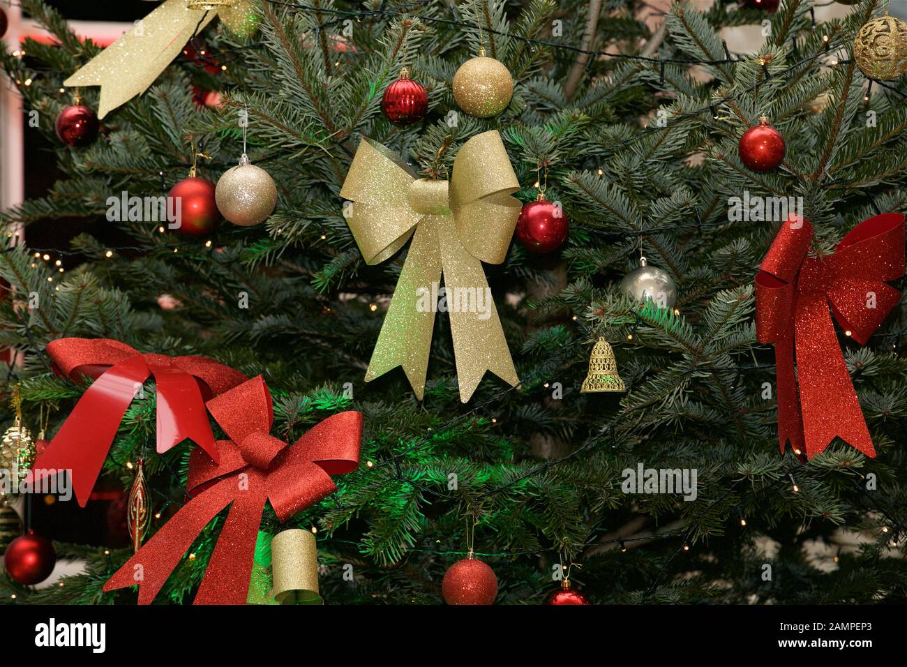Weihnachtshintergrund: Nahaufnahme eines dekorierten Weihnachtsbaums mit Bändern und Baubeln. Stockfoto