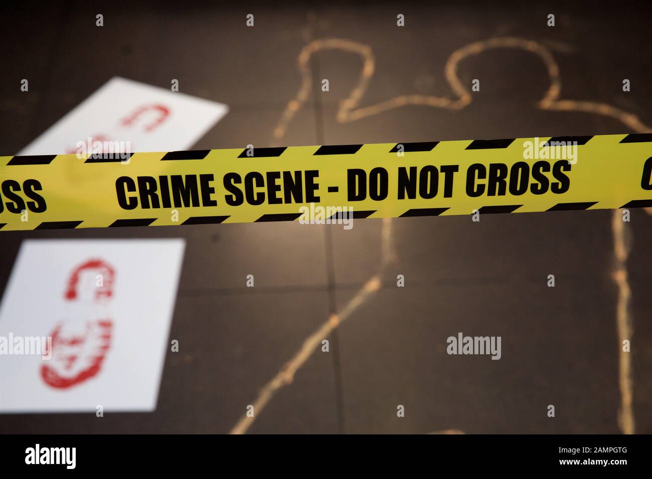 Mock Crime Scene mit gelben Polizei cordon Ribbon und Kreide Körperumriss. Stockfoto