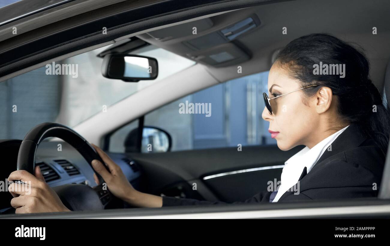Selbstbewusste Frau im Business-Anzug sitzt im Auto nationale Sicherheitsmitarbeiterin im Dienst Stockfoto
