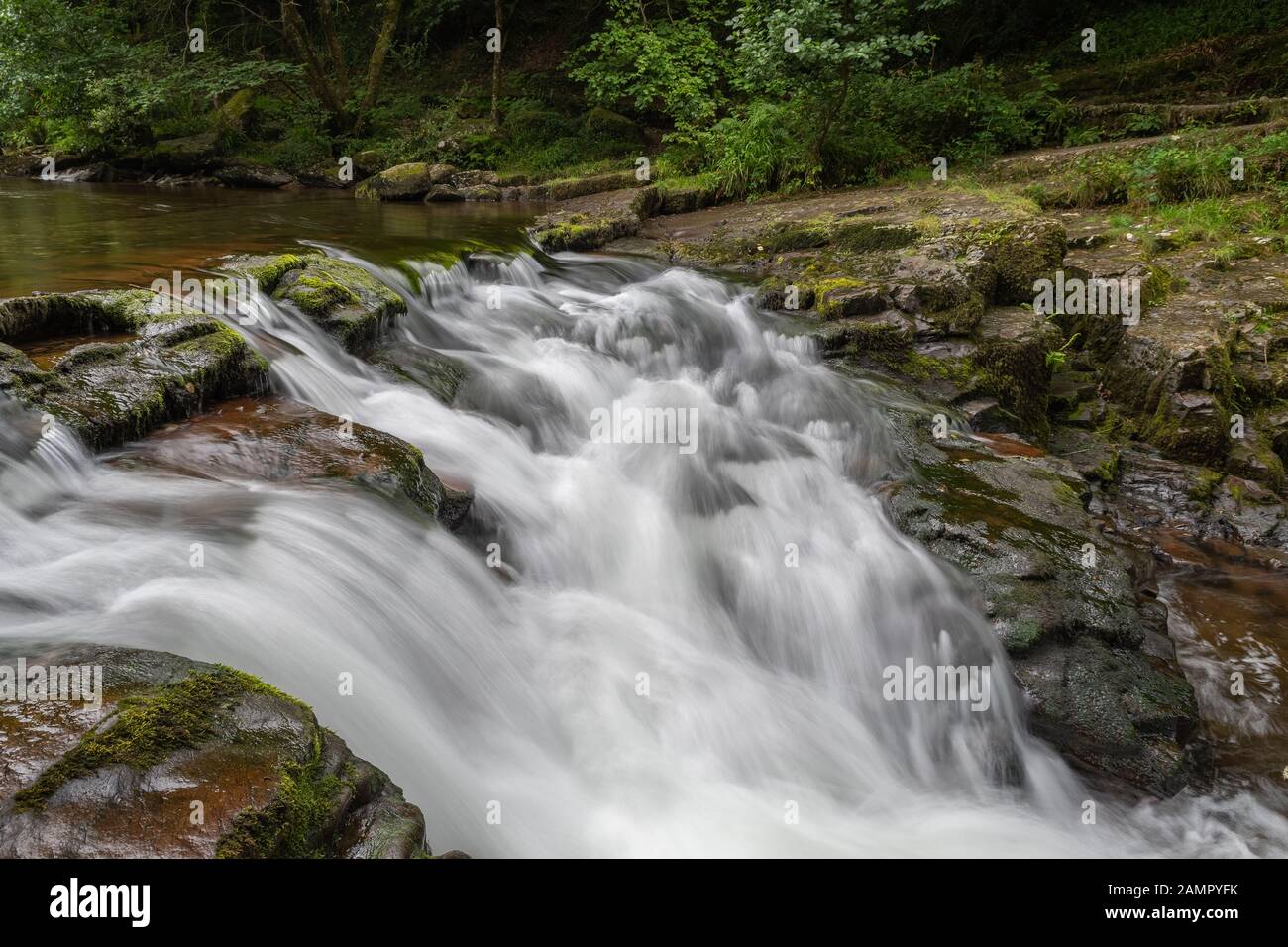Lange Exposition des Wasserfalls am Watersmeet Bridge Pool in Watersmeet in Devon Stockfoto