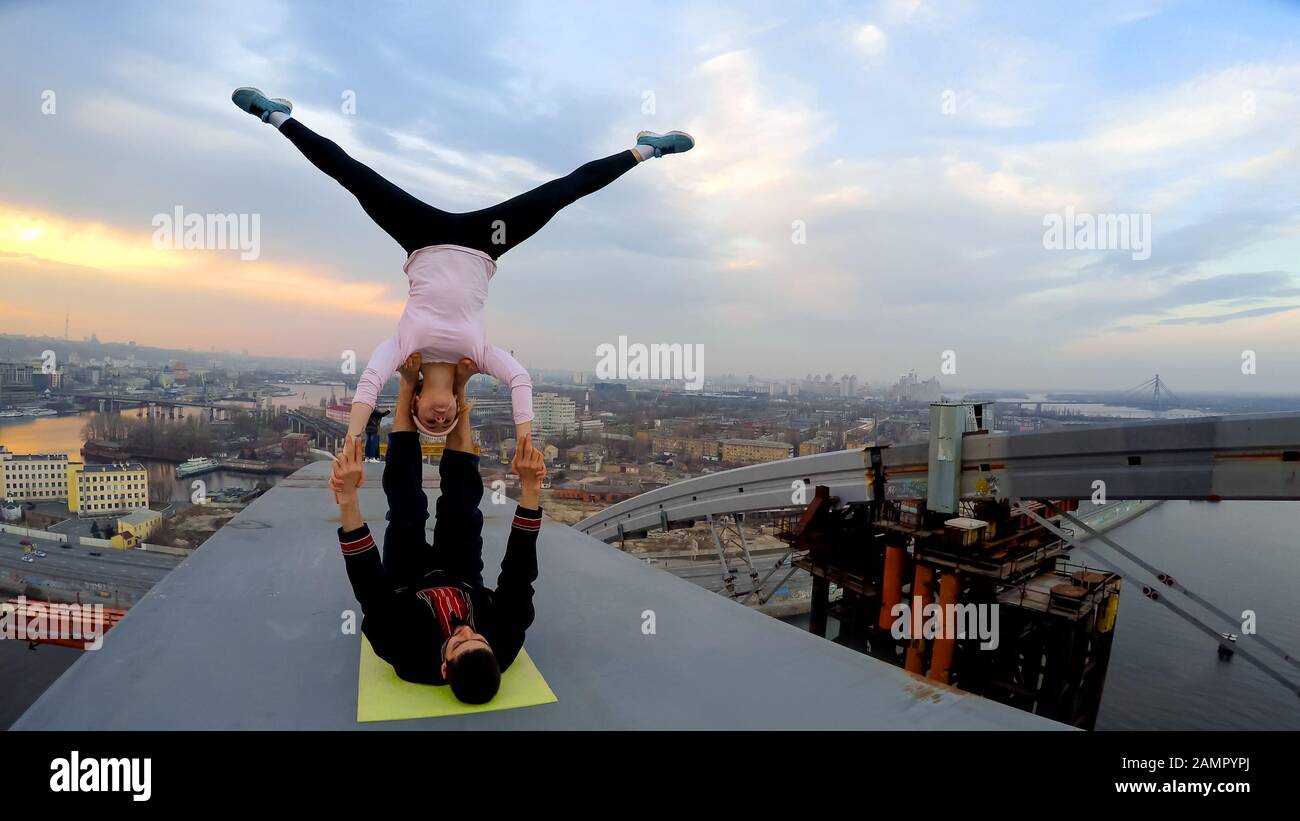 Gefährliche Stunts von Profisportlern auf hoher Brücke, Acro Yoga Posen Stockfoto