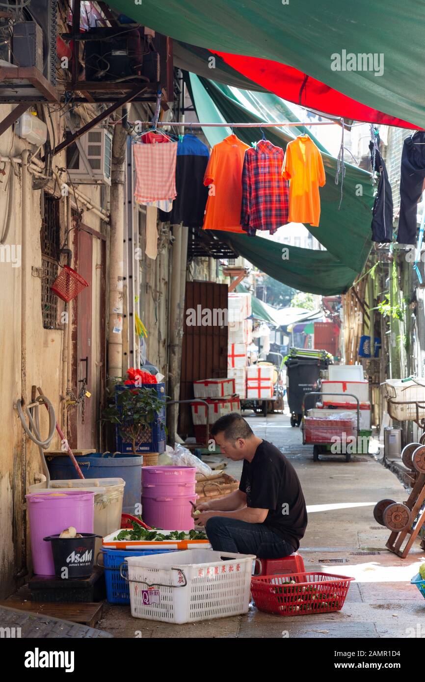 Hong Kong man arbeitet an der Zubereitung von Lebensmitteln in den Hintergassen, Kowloon, Hong Kong Asia Stockfoto