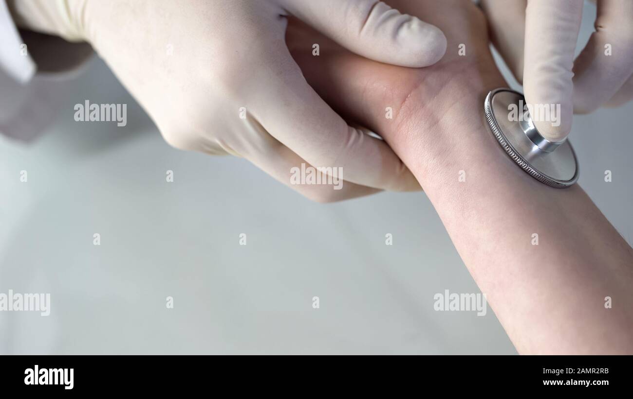 Stethoskop am weiblichen Handgelenkprüfimpuls, Integritätsprüfung, Erste-Hilfe-Nahaufnahme Stockfoto
