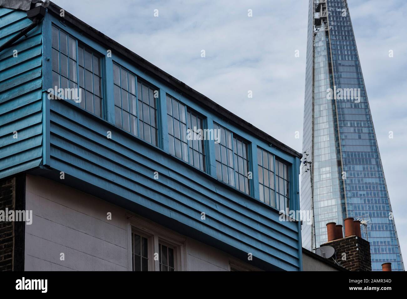 Ein georgianisches Gebäude aus Holz und Backstein im Vordergrund, das vor dem Hintergrund der modernen Glas- und Stahlarchitektur des Shard steht. Stockfoto