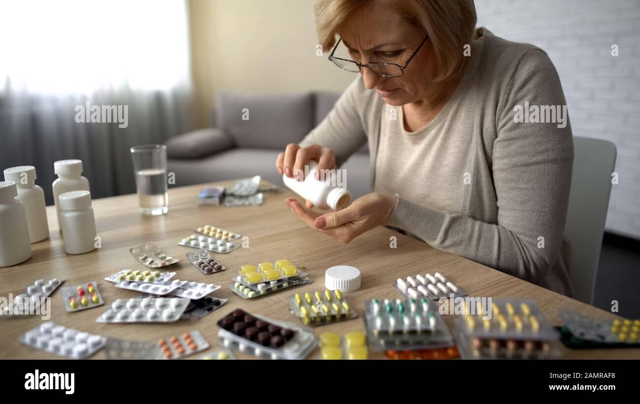 Alte Frauen nehmen Kapseln aus Flaschen Selbstmedikationspillen sucht Obsession Stockfoto