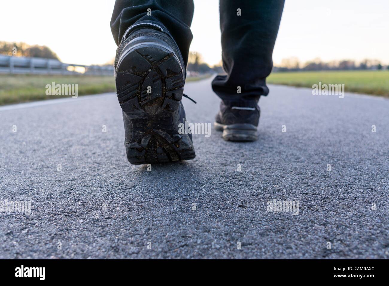 Die Nahaufnahme von Wanderschuhen auf der Straße, ausgewählte Fokussierung auf den linken Schuh Stockfoto