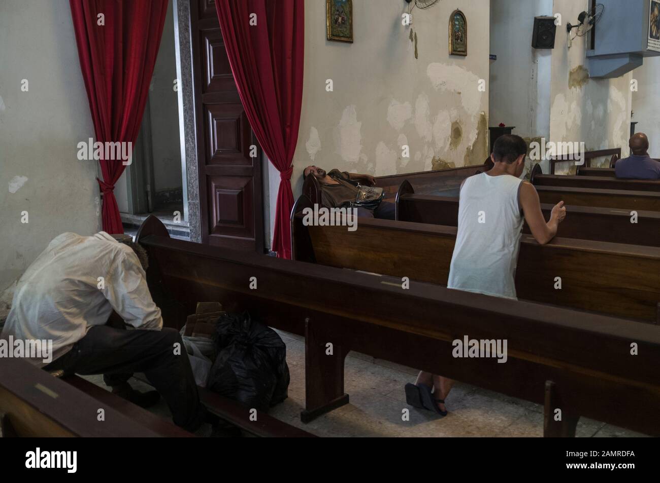 Obdachlose schlafen tagsüber in der katholischen Kirche im Stadtzentrum von Rio de Janeiro - suchen nach sicherem Ort. Stockfoto