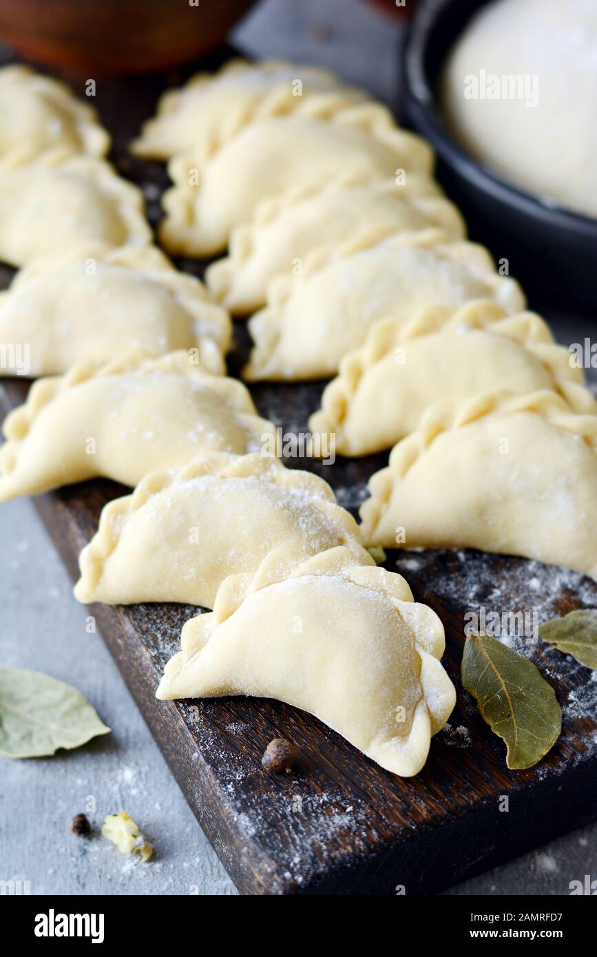 Knödel mit Kartoffeln mit Kräutern auf einem blauen Hintergrund. Wareniki, vareniki, Pierogi, pyrohy-Knödel mit Füllung. Stockfoto