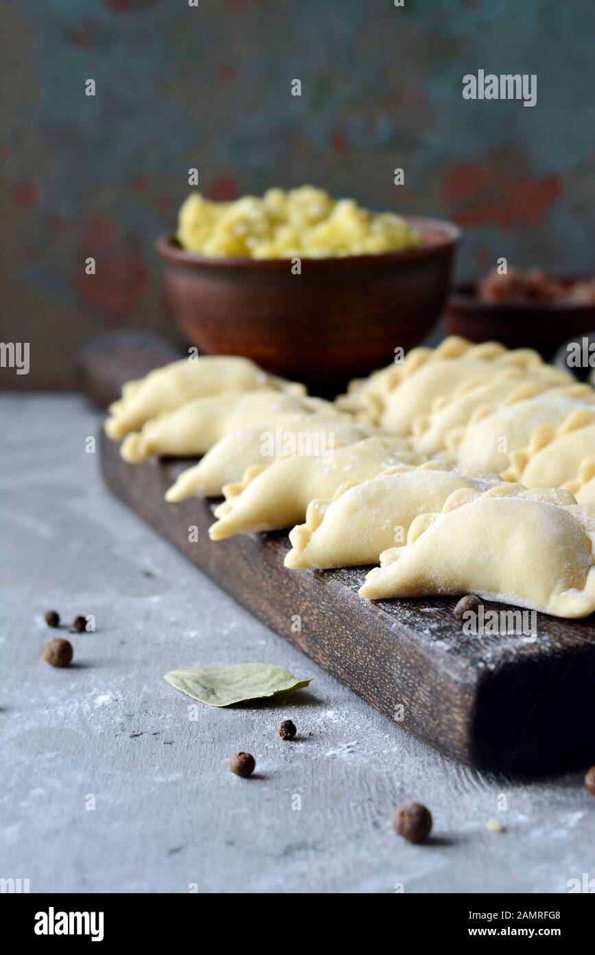 Knödel mit Kartoffeln mit Kräutern auf einem blauen Hintergrund. Wareniki, vareniki, Pierogi, pyrohy-Knödel mit Füllung. Stockfoto