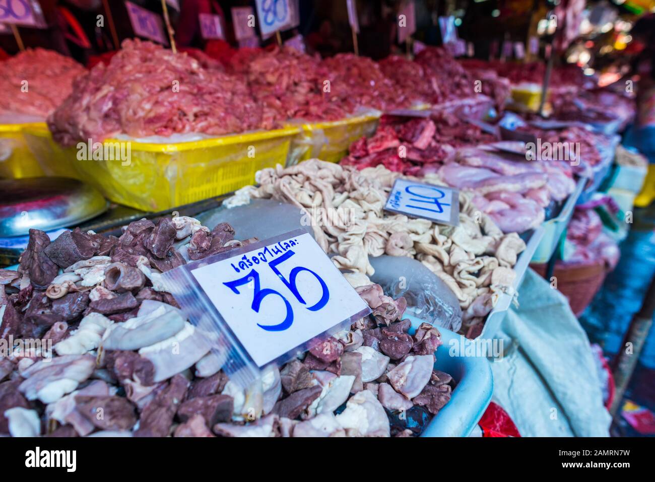 Kholng Toei Market Bangkok: Markt Stall, der verschiedene Fleischschnitte verkauft, darunter Magen, Darm und andere Organe in Eimern und Preismarkierungen Stockfoto