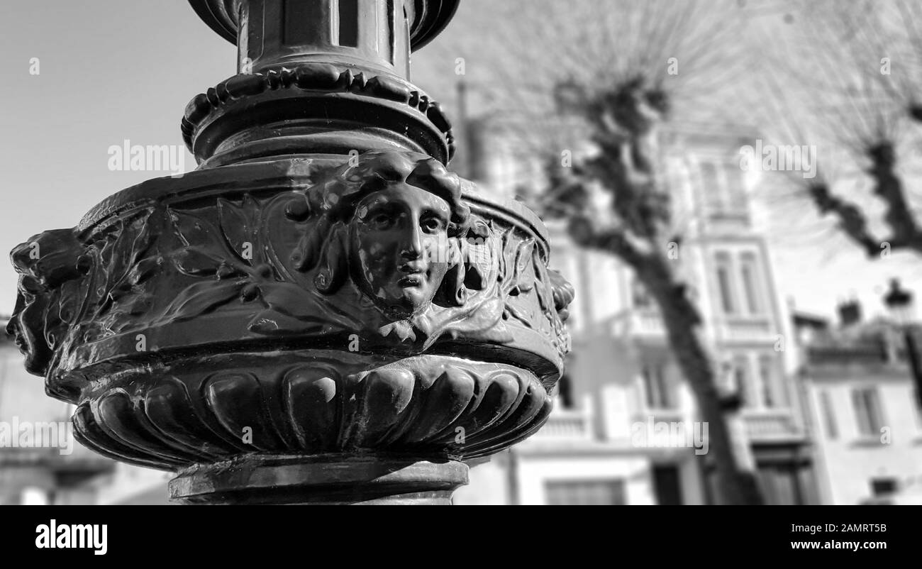 Kopf Skulptur und architektonische Ornamente mit typischen Häusern im Hintergrund. Schwarz-weiß Stil. Stockfoto