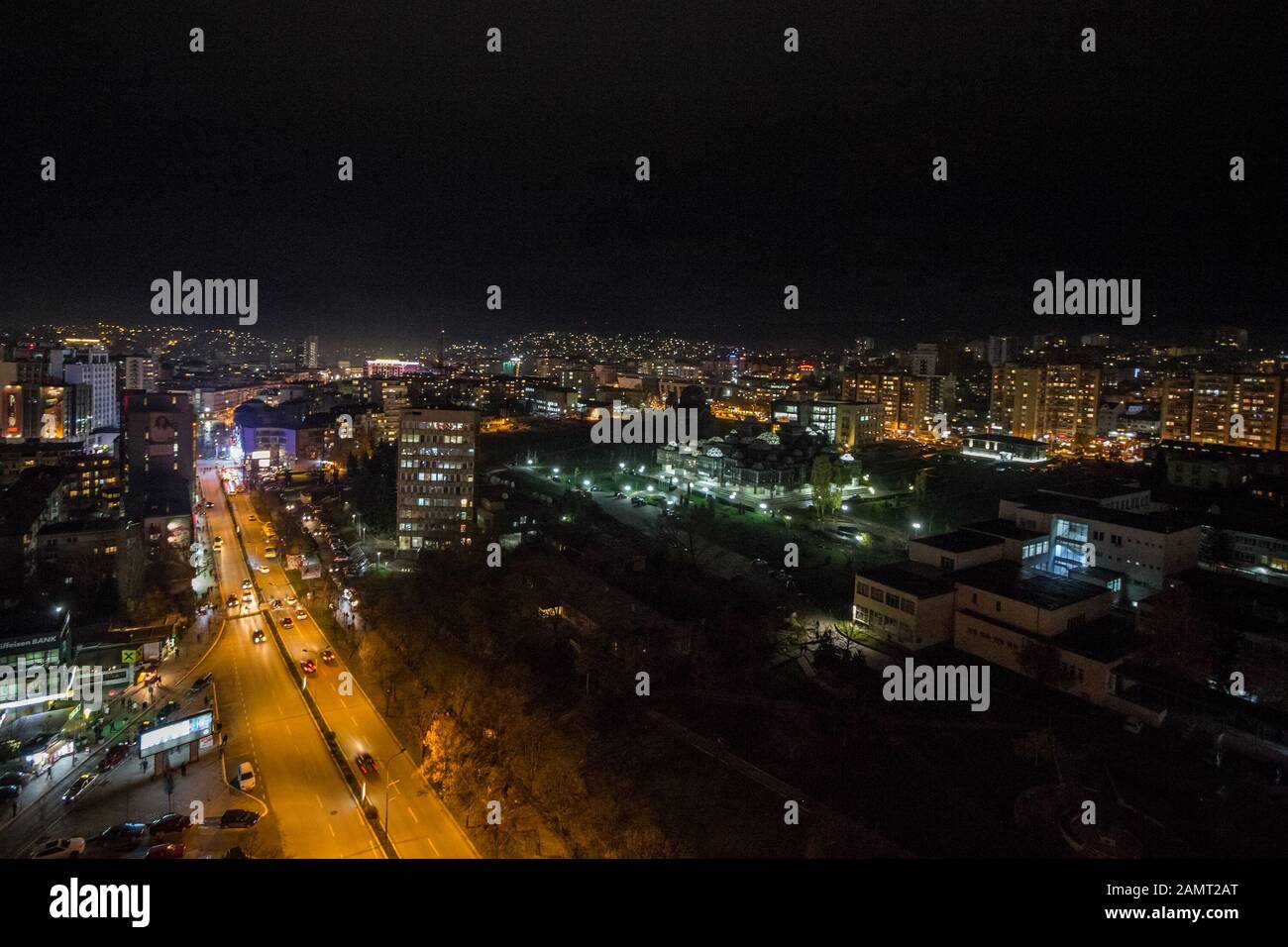 Prishtina, KOSOVO - 11. NOVEMBER 2016: Nachtansicht des Mother Tereza Boulevard in Prishtina mit vorbeifahrenden Autos und Wahrzeichen der Innenstadt wie der National Li Stockfoto