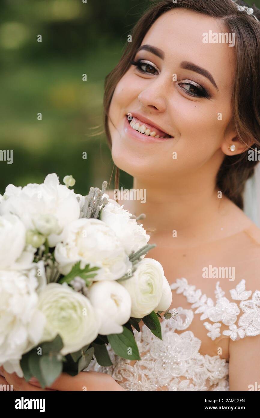 Close up Portrait von wunderschöne Braut mit Blumenstrauß. Glückliche Frau lächeln Stockfoto