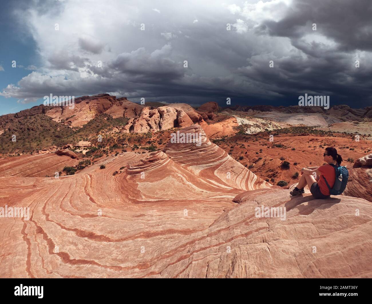 Frau sitzt auf Felsen, Valley of Fire State Park, Nevada, USA Stockfoto